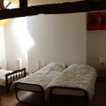 Chambre avec plusieurs lits et poutres apparentes dans un gîte 15 personnes du Domaine de Beauregard (35)