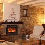 Coin salon avec cheminée et fauteuils confortables dans un gîte 15 personnes du Domaine de Beauregard (35)