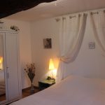 Chambre avec poutre apparente et armoire dans un gîte 15 personnes du Domaine de Beauregard (35)